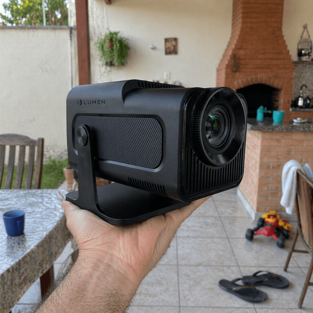 Mini Projetor Lumen HY320 sendo segurado na mão